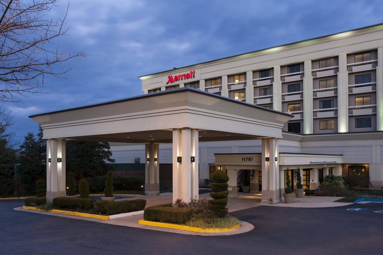 Exterior view of a Hampton Inn hotel entrance at dusk.
