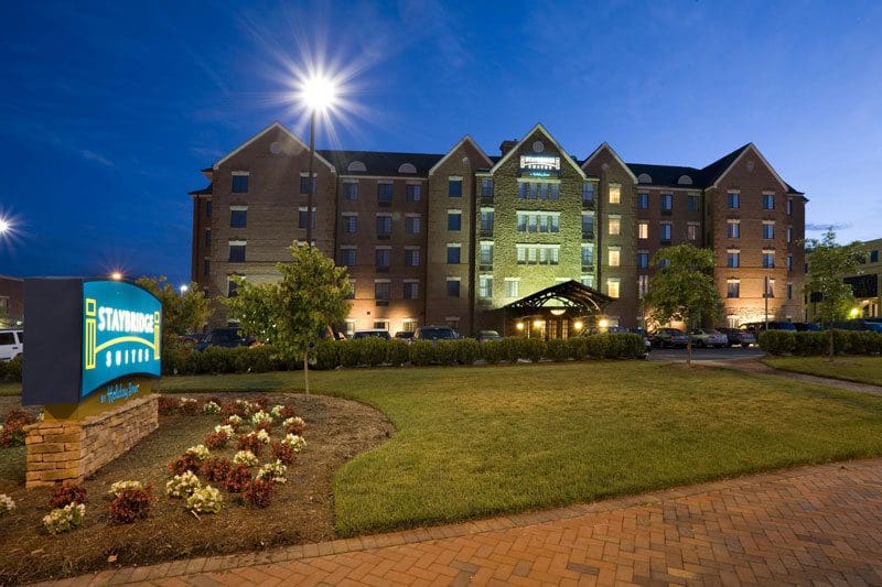 A well-lit brick building at night with manicured landscaping.