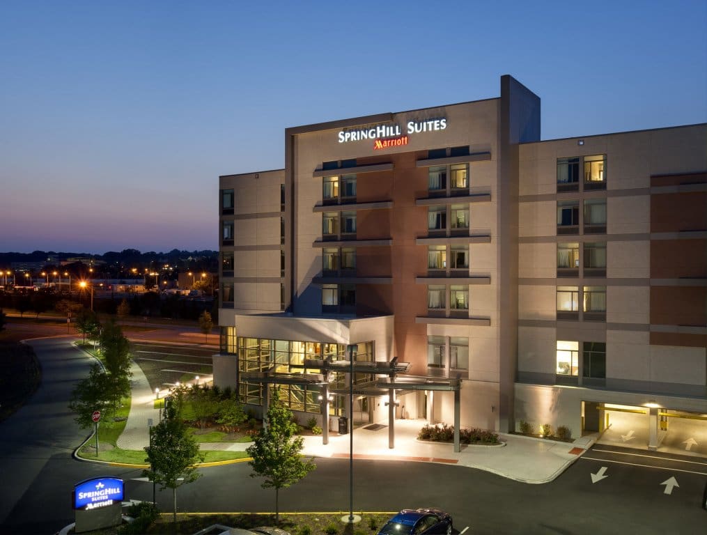 Evening view of a modern Hampton Inn hotel with illuminated entrance and balconies.