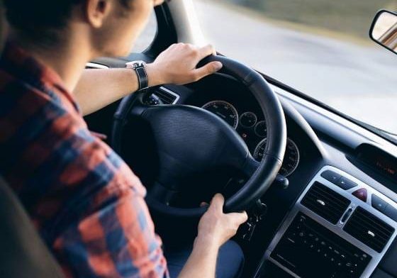Man driving a car, focused on the road ahead.